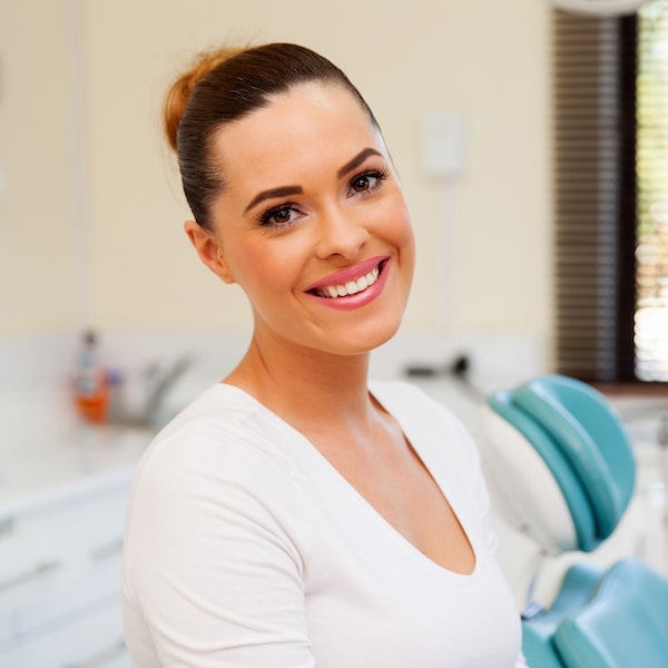 A young woman smiling in a dental office